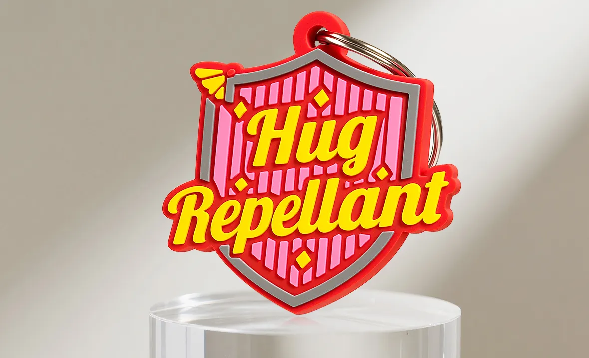 Shield PVC keychain with "Hug Repellant" text Shield PVC keychain with "Hug Repellant" text