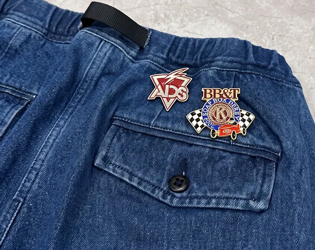 “ADS” and “BB&T” soft enamel pins on blue denim pants
