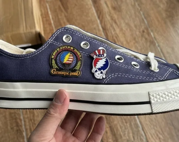 Custom pins attached to a navy blue canvas shoe