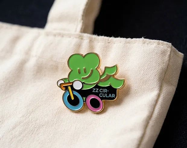 A cute green character on a bike pin on a canvas tote bag.
